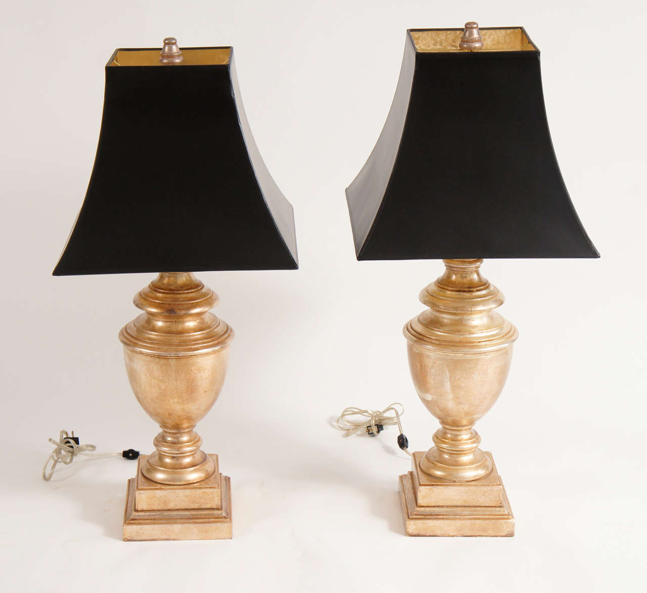 Two lamps by Baker, Knapp and Tubbs of gilded wood, one with a natural crack in the wooden body. We will restore upon request, should you prefer a less organic look. Each lamp accommodates two 60 watt bulbs and comes with fabulous, original finials.